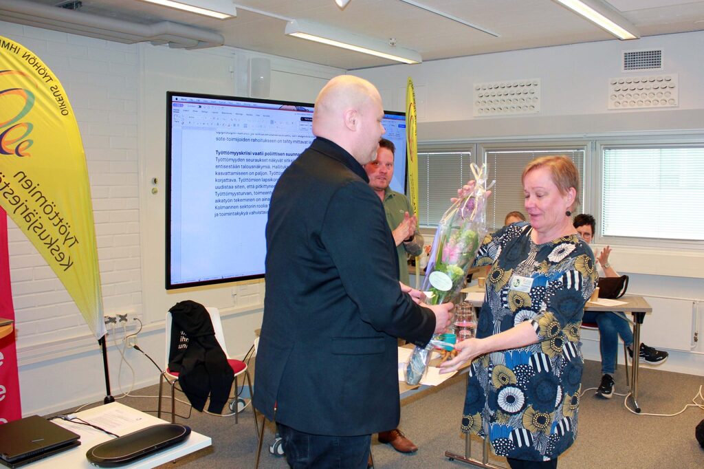 Työttömien Keskusjärjestön vuosikokous, väisyvä vt. puheenjohtaja Ritva Kurkinen sai kukkien lisäksi vuolaat kiitokset hyvästä työstään Keskusjärjestön hallituksen kipparina.